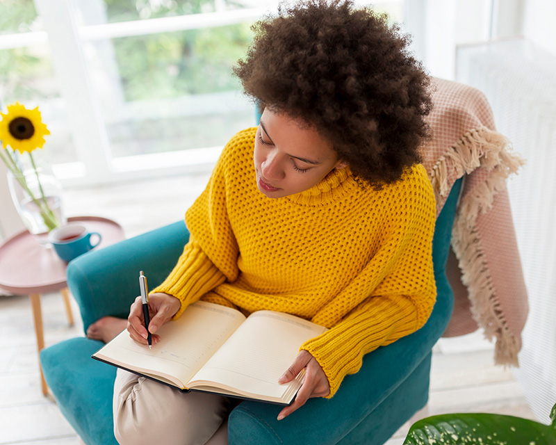 Adult woman with a journal during counseling session in Plano