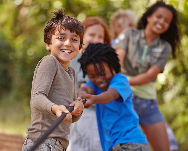 Group of multi-cultural kids pulling on a rope
